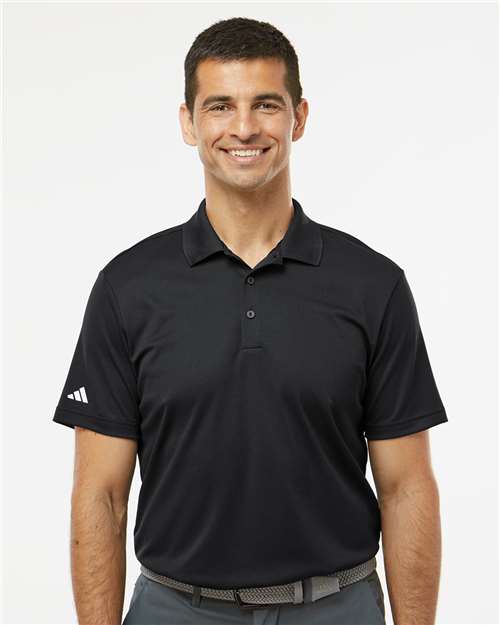 Man wearing a black Adidas polo shirt against a white background