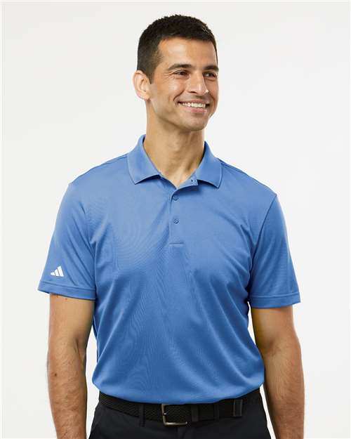 Man wearing a blue Adidas polo shirt on a white background