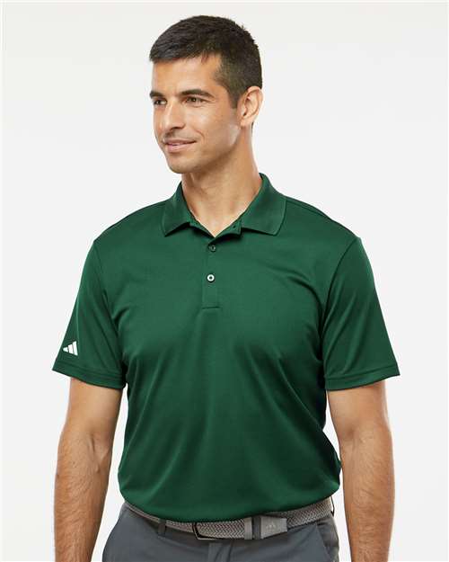 Man wearing a green Adidas polo shirt on a white background