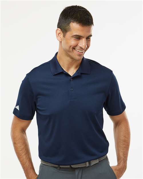 Man wearing a navy blue polo shirt with a white background
