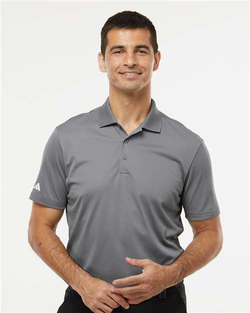Man wearing a gray Adidas polo shirt on a white background