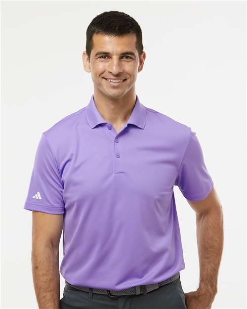 Man wearing a purple Adidas polo shirt on a white background