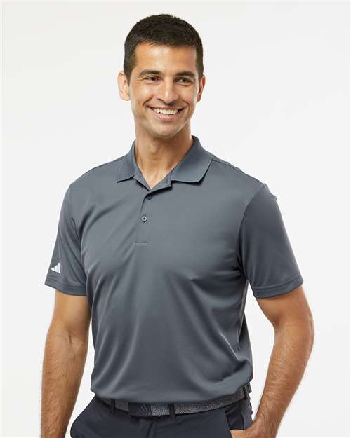 Man wearing a gray Adidas polo shirt on a white background