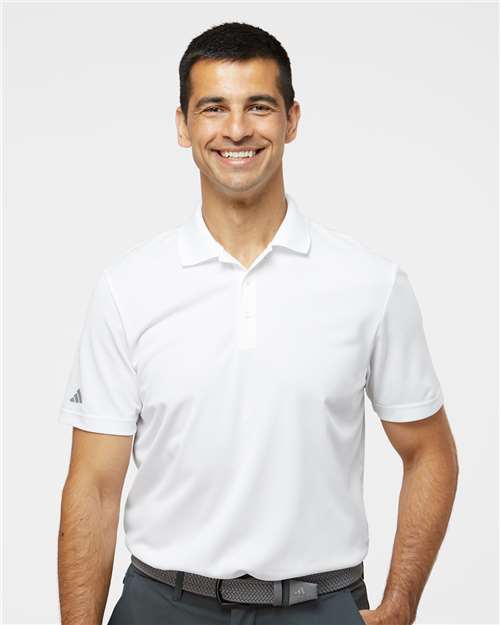 Man wearing a white short-sleeve polo shirt with a collar and a small logo on the left sleeve.