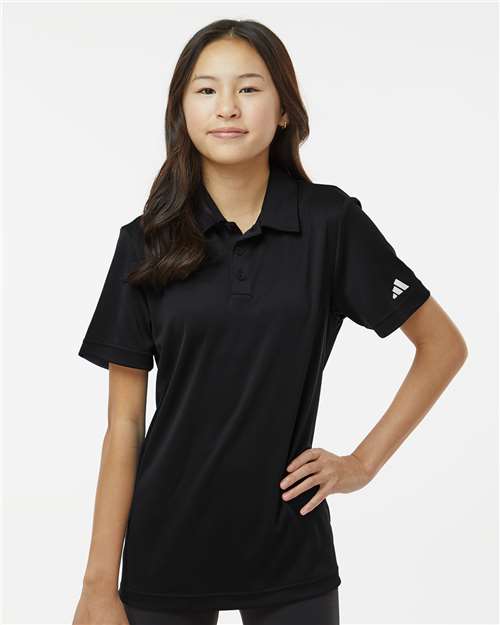 Person wearing a black polo shirt with a brand logo on a white background