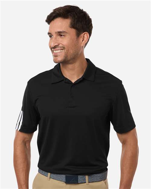 Man wearing a black polo shirt with a white logo on a light gray background