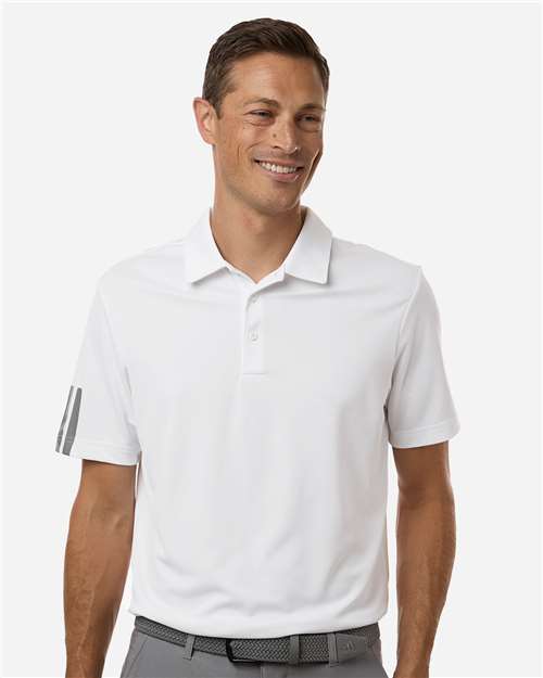 Man wearing a white polo shirt with gray pants on a white background