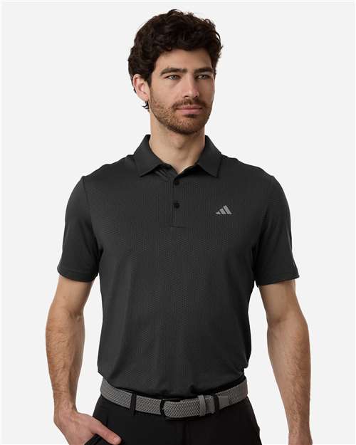 Man wearing a black Adidas polo shirt on a white background