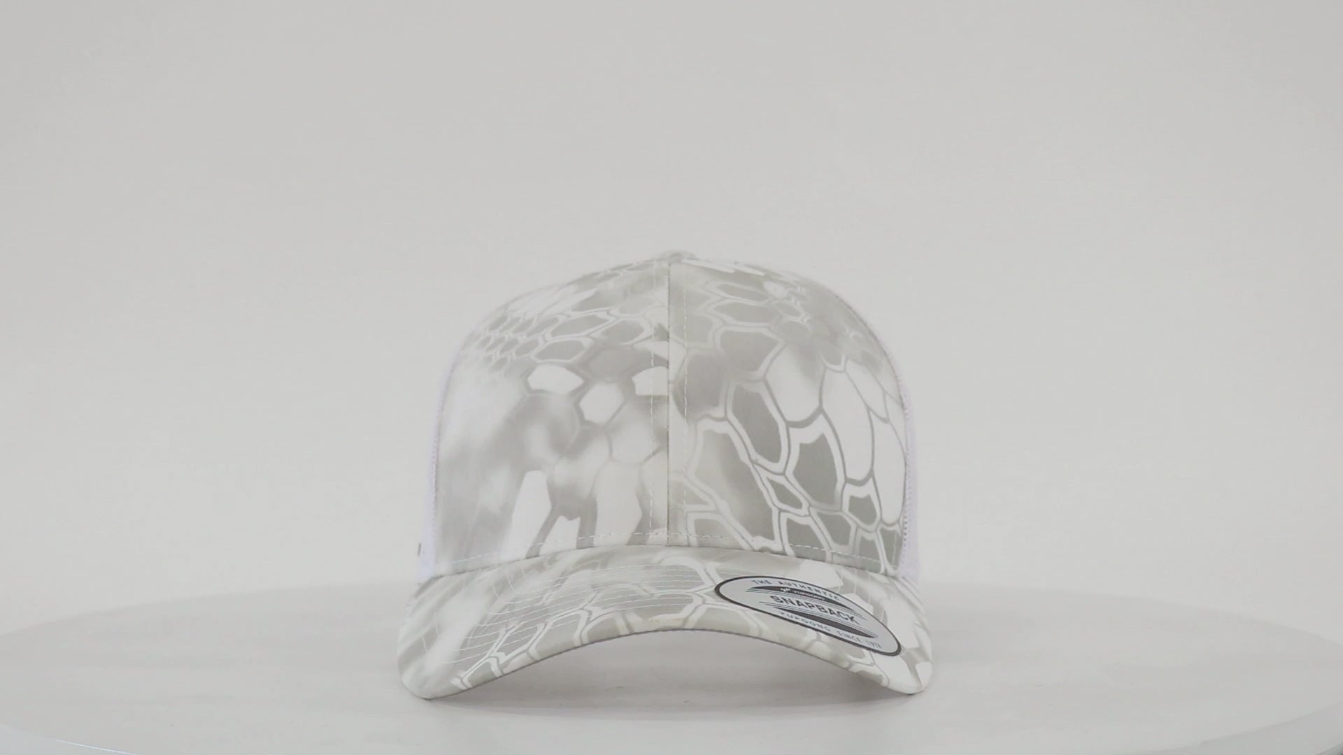 Yupoong 6606 retro trucker cap with custom embroidered logo, structured front, mesh back, and snapback closure.